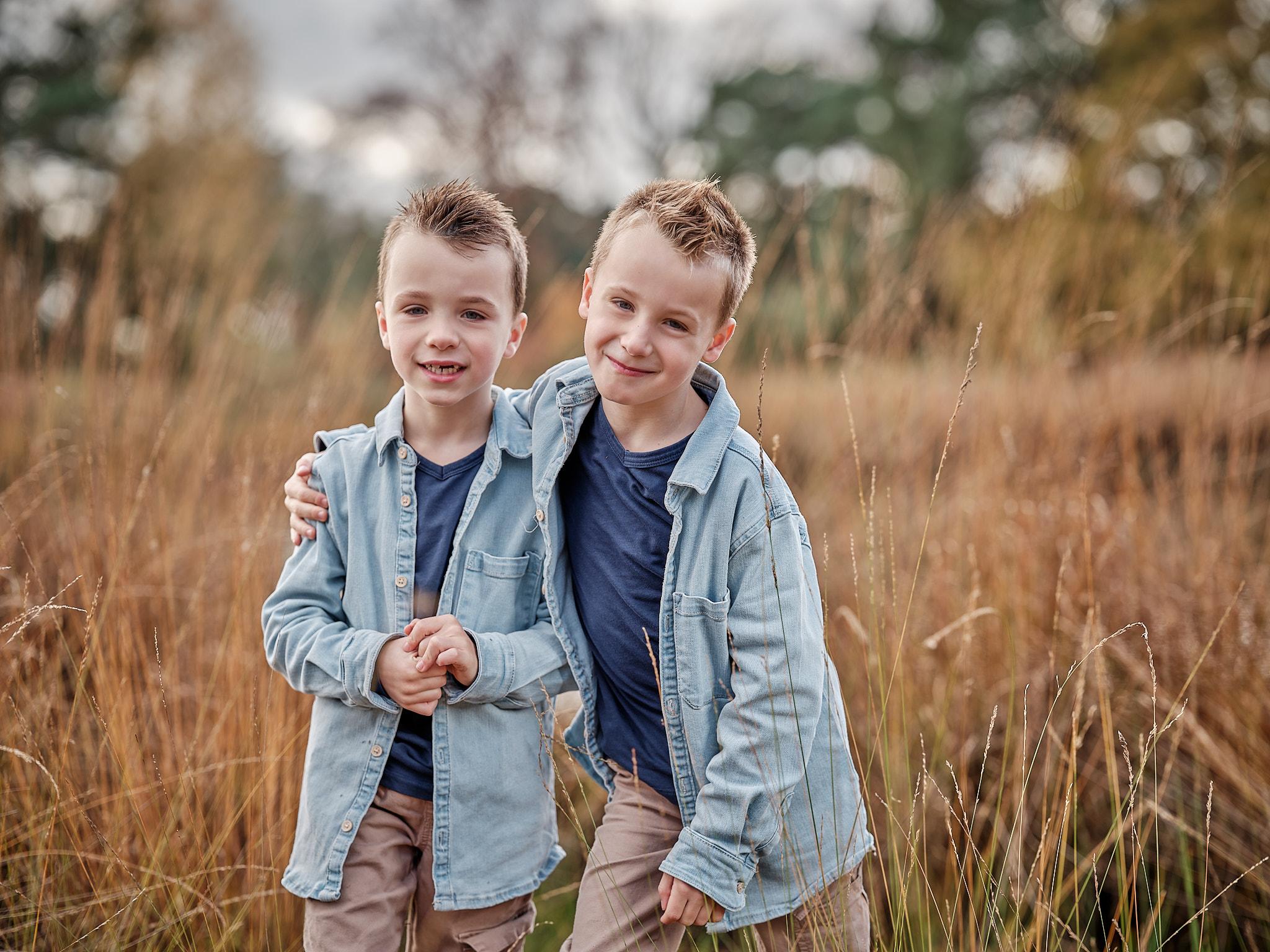 Portret van twee broertjes in het herfstgras tijdens een familieshoot in Nijmegen