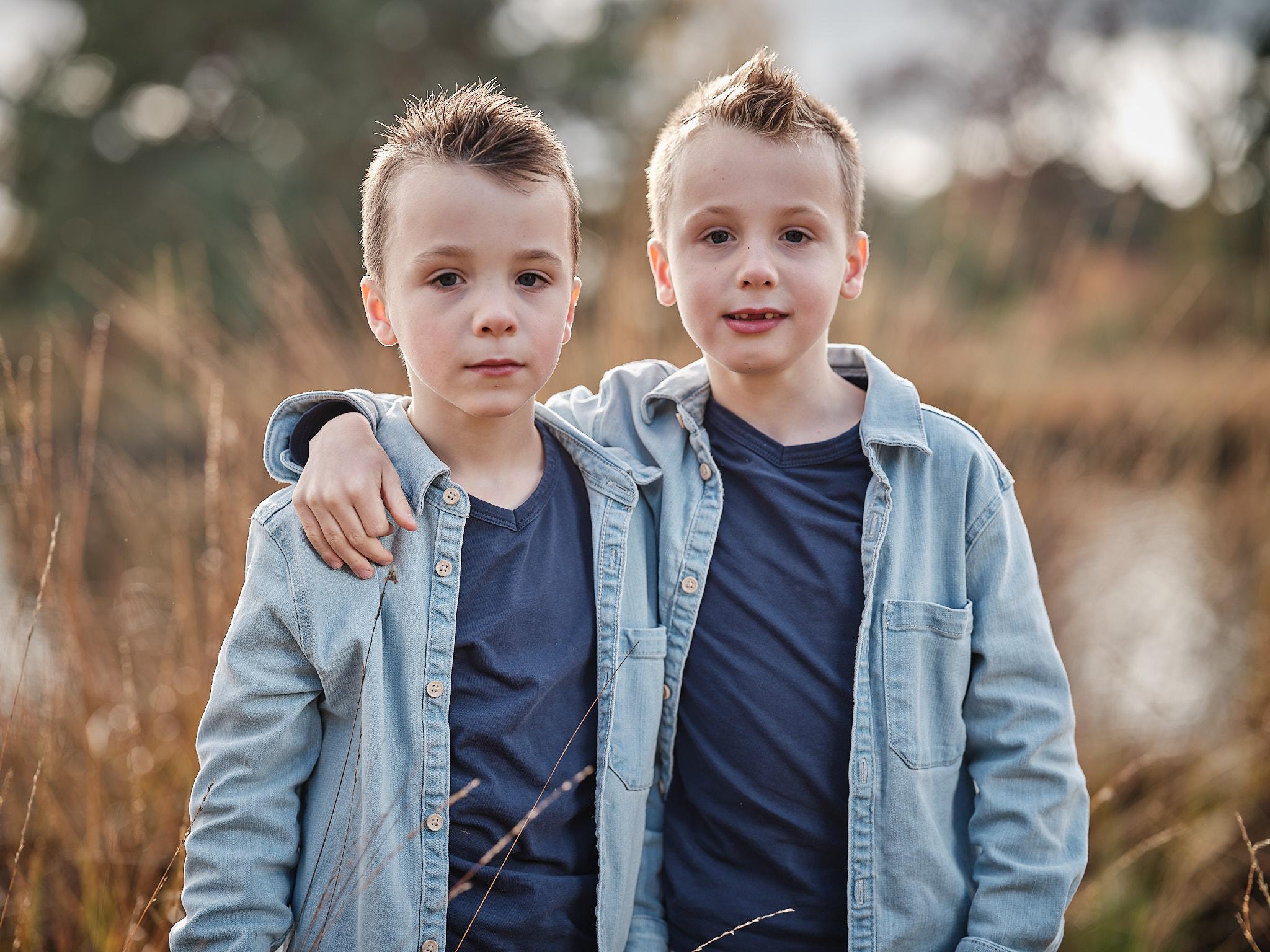 Broertjes die samen poseren met arm om elkaar tijdens een familieshoot in de natuur bij Nijmegen