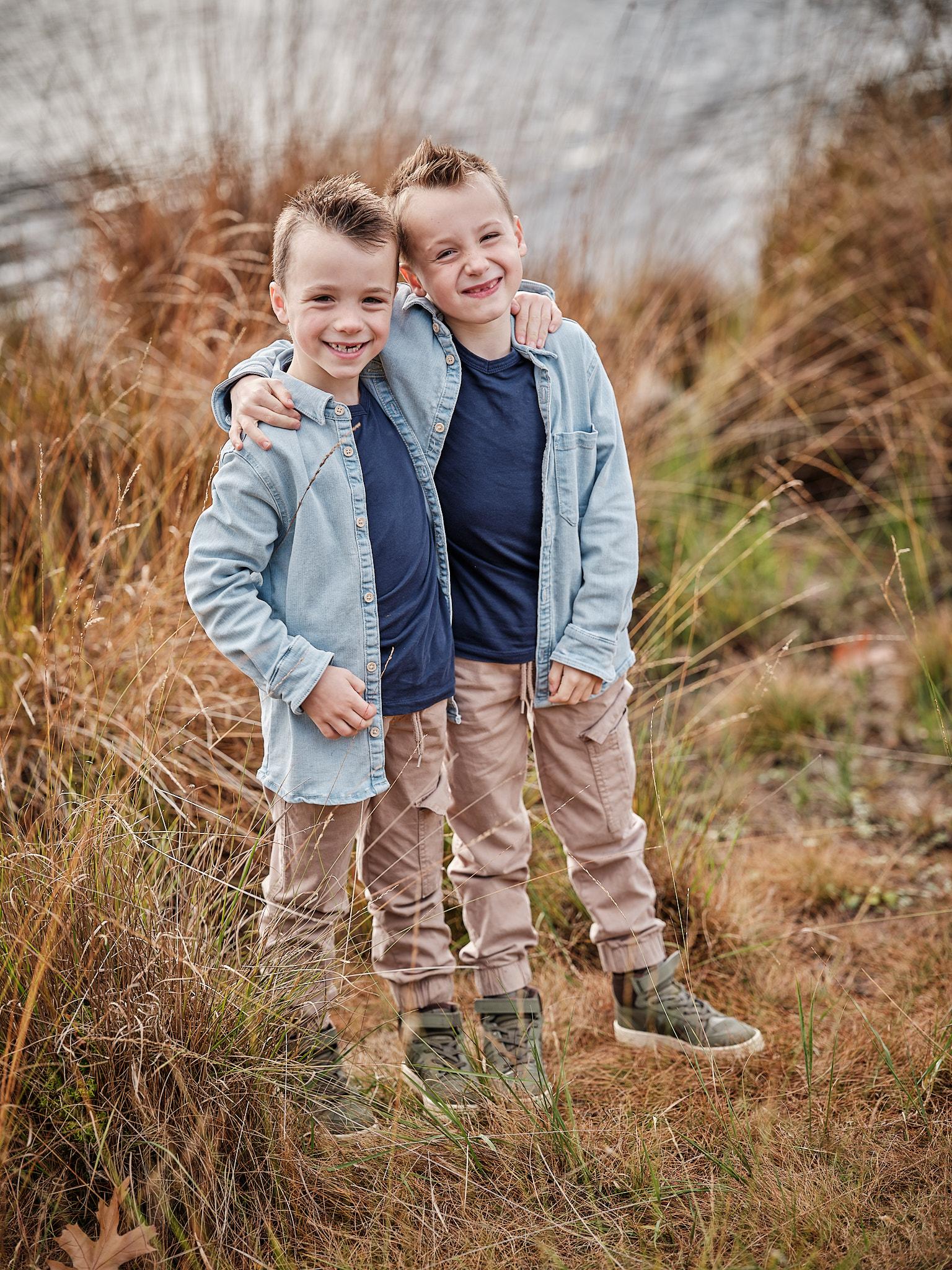 Vrolijke foto van twee broertjes bij het water tijdens een familiefotografie sessie in Nijmegen