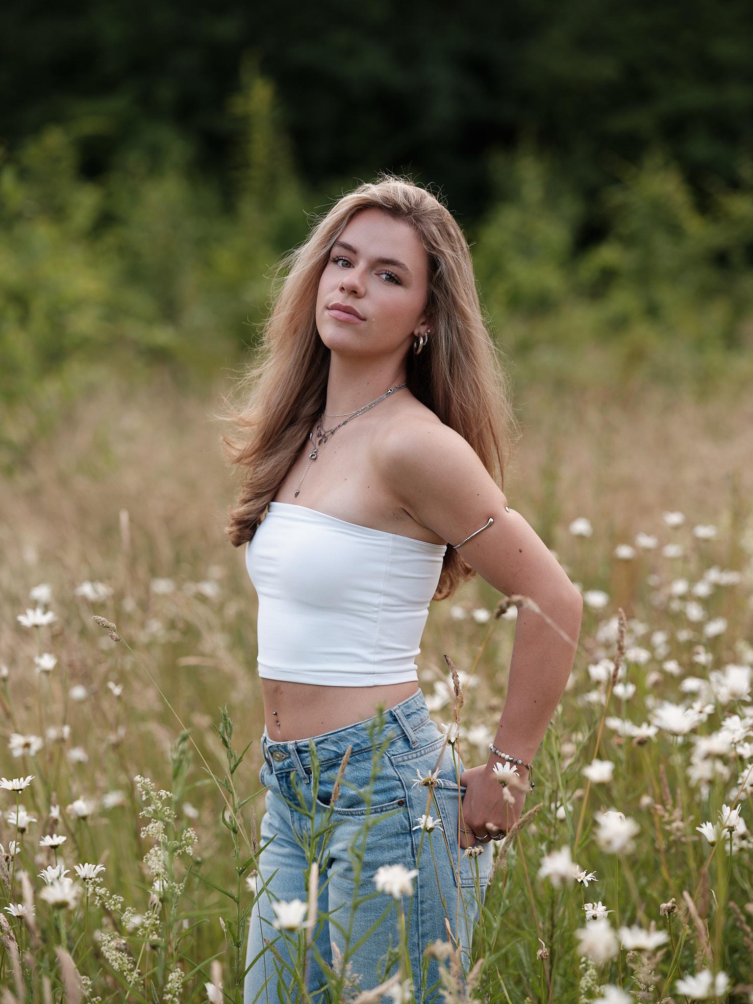 Model staand in veld met witte bandeau top