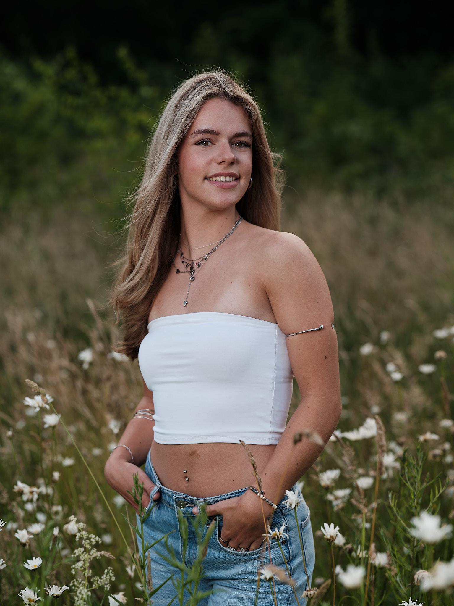 Model staand tussen bloemen met ontspannen houding